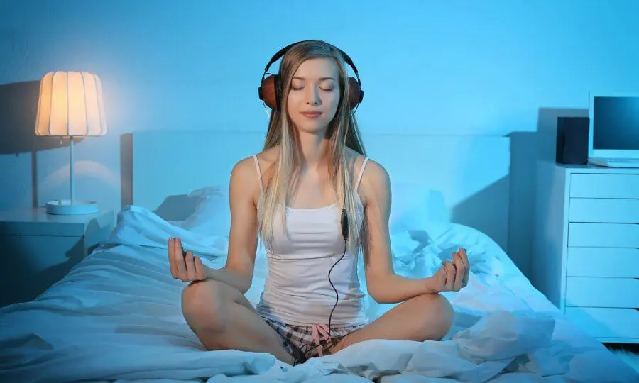 Young woman meditating and listening to music
